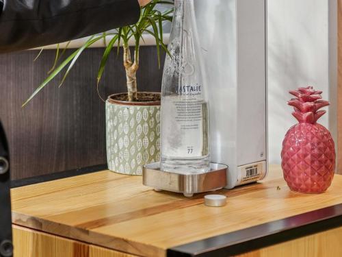 une bouteille d'eau et un ananas sur une table en bois dans l'établissement Mercure Paris Porte d'Orleans, à Montrouge