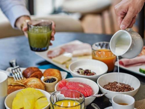 einen Tisch mit einem Tablett mit Frühstückszutaten in der Unterkunft Mercure Paris Porte d'Orleans in Montrouge