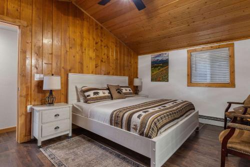 a bedroom with a bed and a wooden wall at Cabin 3- Cozy updated cabin 5 min to RMNP in Estes Park