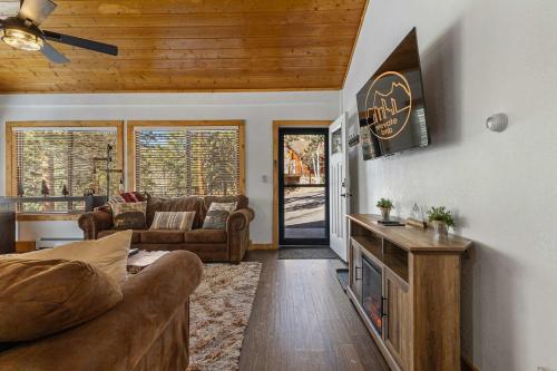 a living room with a couch and a tv at Cabin 3- Cozy updated cabin 5 min to RMNP in Estes Park