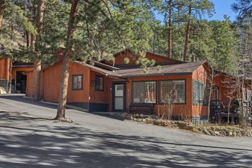 a house with a tree in front of it at Cabin 3- Cozy updated cabin 5 min to RMNP in Estes Park