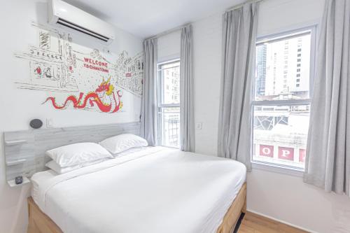 a white bedroom with a large bed and a window at JGSTAY - Times Square in New York