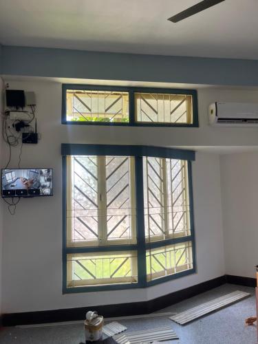 Zimmer mit 3 Fenstern in einem Gebäude in der Unterkunft Loylet Carlton in Tambaram