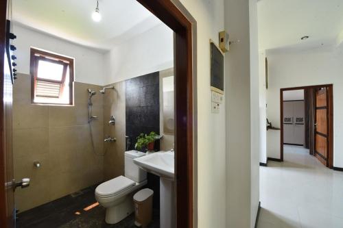 un bagno con wc, lavandino e doccia di Villa Serein - Giant Suit a Galle