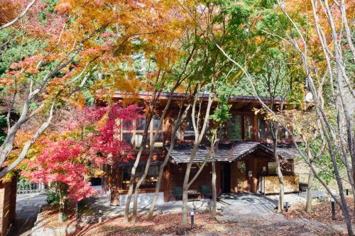 a house in the middle of some trees at SHELTER都留 森とに包まれた貸切ヴィラ最大10名ok 都心から90分 10人貸切サウナ 雨でもBBQ in Tsuru