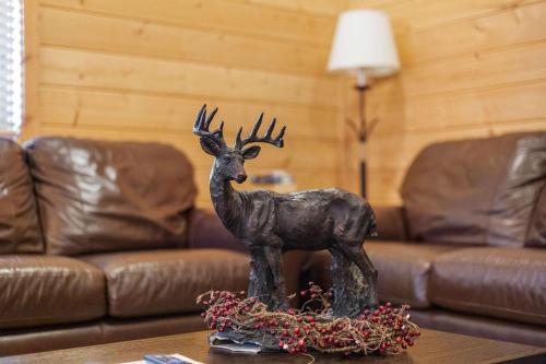 eine Hirschstatue auf einem Tisch in einem Wohnzimmer in der Unterkunft Cabin 9- Spacious cabin- 4 King beds- 2 baths in Estes Park
