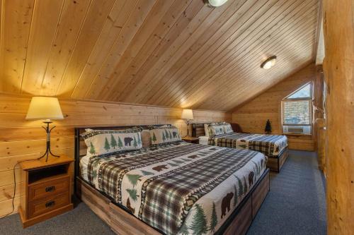 ein Schlafzimmer mit zwei Betten in einer Blockhütte in der Unterkunft Cabin 9- Spacious cabin- 4 King beds- 2 baths in Estes Park