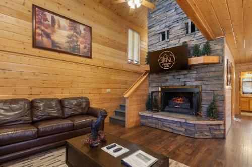 a living room with a couch and a stone fireplace at Cabin 9- Spacious cabin- 4 King beds- 2 baths in Estes Park