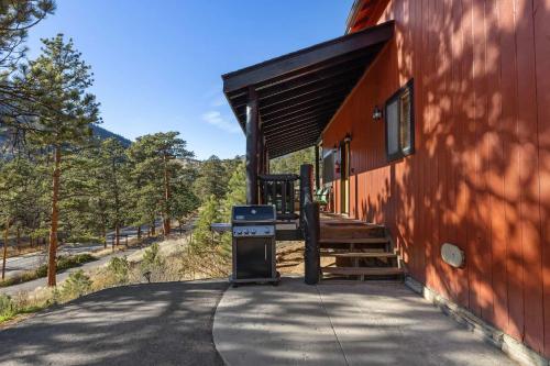 a building with a grill on the side of it at Cabin 9- Spacious cabin- 4 King beds- 2 baths in Estes Park