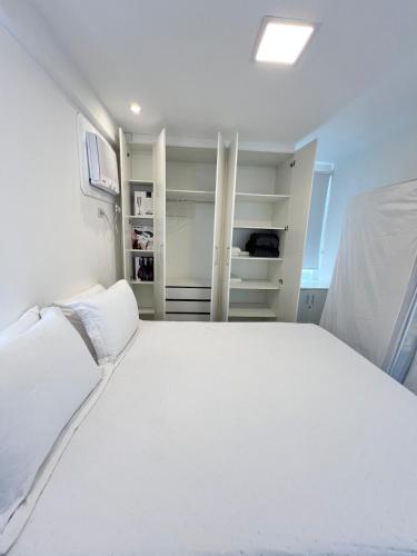 a bedroom with a large white bed and shelves at Cobertura Ponta Verde Vistar Mar in Maceió