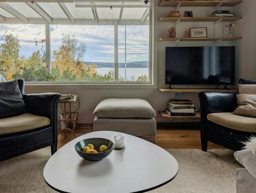 a living room with a television and a table and chairs at Cabin With Views Of The Oslofjord On Nesodden in Nordstrand