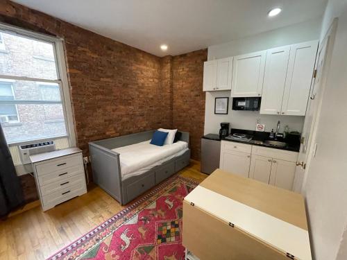 a living room with a couch and a kitchen at Nest 1 bedroom Aparthotel with kitchenette in New York