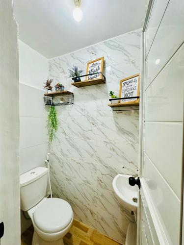 a bathroom with a toilet and a sink at The ComfyNook Hostel in Santa Maria