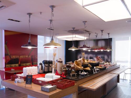 ibis Passo Fundo Centro في باسو فوندو: مطعم يقدم بوفيه طعام وإضاءة معلقة