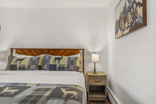 a bedroom with a bed and a lamp on a night stand at Cabin 17 - King Bed New Kitchen & Bath in Estes Park