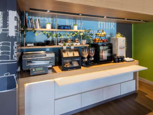 a kitchen with a counter with aperature at Ibis Budget - Casula Liverpool in Liverpool