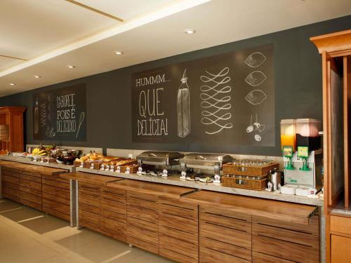 a bakery with a counter with food on it at ibis Vitoria da Conquista in Vitória da Conquista
