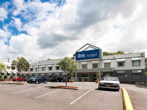 a large building with cars parked in a parking lot at ibis Budget - Newcastle in Newcastle