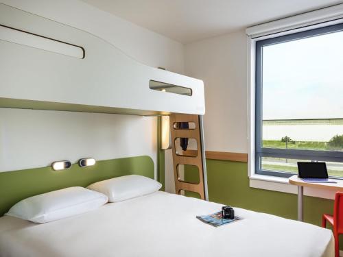 une chambre avec un lit, un bureau et une fenêtre dans l'établissement ibis budget Paris Coeur d'Orly Airport, à Orly