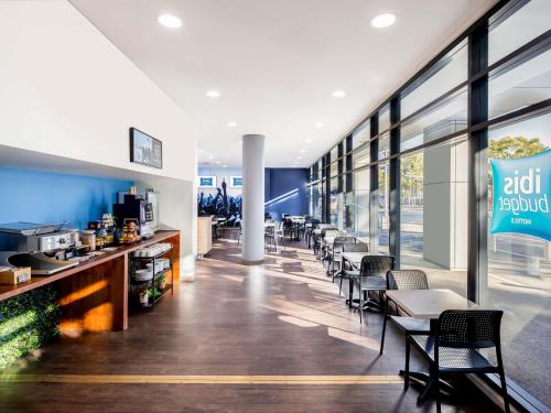 um restaurante com cadeiras e um bar com lareira em ibis Budget Sydney Olympic Park em Sidney