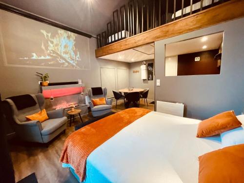 ein Schlafzimmer mit einem großen Bett und einem Tisch und Stühlen in der Unterkunft Suite Phoenix avec Cheminée, Terrasse et Videoprojecteur in Angoulême