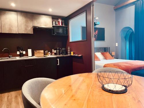 eine Küche und ein Esszimmer mit einem Holztisch und Stühlen in der Unterkunft Suite Phoenix avec Cheminée, Terrasse et Videoprojecteur in Angoulême