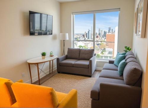 a living room with a couch and a chair and a window at Urban Chic residence in Central LA in Los Angeles