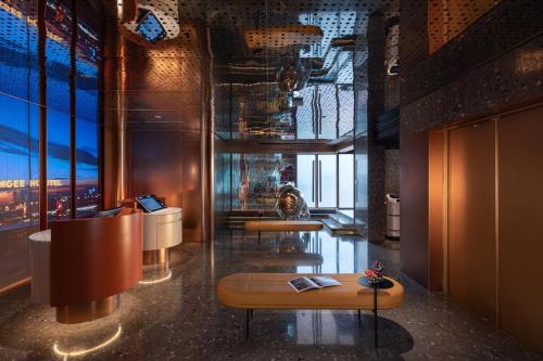 FunGee X Hotel 长沙国金中心南门口地铁站店 في تشانغشا: لوبي وطاولتين في مبنى