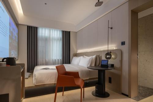 FunGee X Hotel 长沙国金中心南门口地铁站店 في تشانغشا: غرفة فندق مع سرير وطاولة