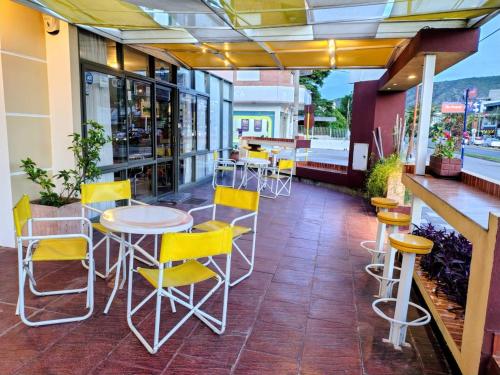 Un restaurante con sillas y mesas amarillas en un patio. en Hotel Ritz, en Villa Carlos Paz