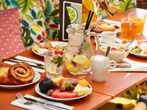 Una mesa cubierta con platos de comida y bebidas. en Mama Shelter Prague, en Praga