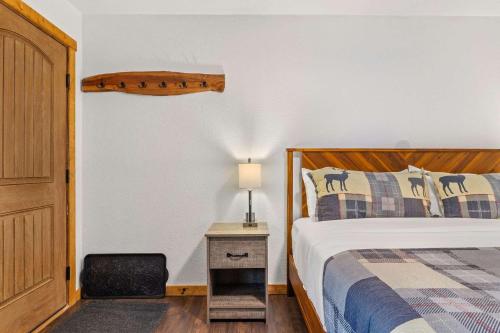 een slaapkamer met een bed en een lamp op een nachtkastje bij Cabin 19- King Studio Gorgeous views Hotel Style in Estes Park