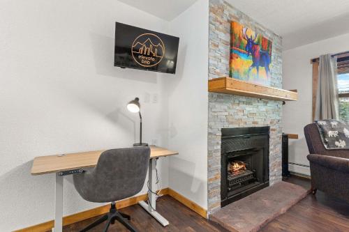 a room with a desk and a fireplace at Cabin 19- King Studio Gorgeous views Hotel Style in Estes Park