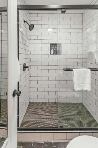 a bathroom with a shower with white tiles at Cabin 18 - King Bed Mountain views Hotel Style in Estes Park