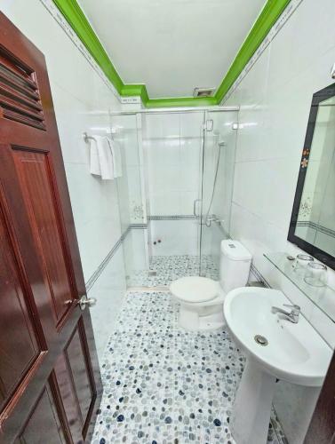 a white bathroom with a toilet and a sink at Thanh Tùng Hotel in Can Tho