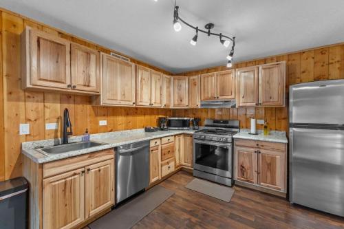 een keuken met houten kasten en roestvrijstalen apparatuur bij Cabin 21- Accessible Unit & King Bed in Estes Park