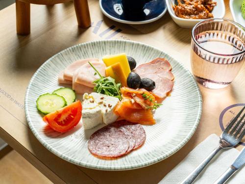 a plate of food with meat and vegetables on a table at Mercure Bucharest Unirii in Bucharest