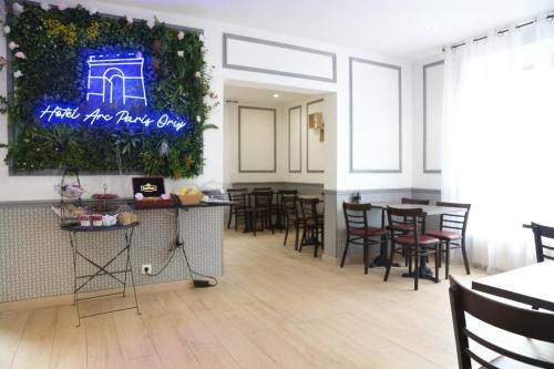 Ein Restaurant mit Tischen und Stühlen und einem Schild mit der Aufschrift „High Five Rave Up“. in der Unterkunft Hotel Arc Paris Porte d'Orléans in Montrouge