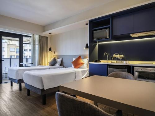 a hotel room with two beds and a table at Mercure Sao Paulo Barra Funda in Sao Paulo
