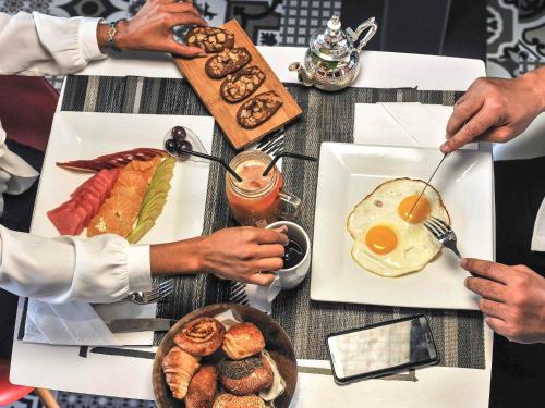 卡萨布兰卡卡萨宜必思旅行者酒店的一群人坐在桌子旁,一边吃早餐