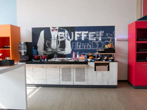 a kitchen with a large poster on the wall at ibis budget Muriae in Muriaé