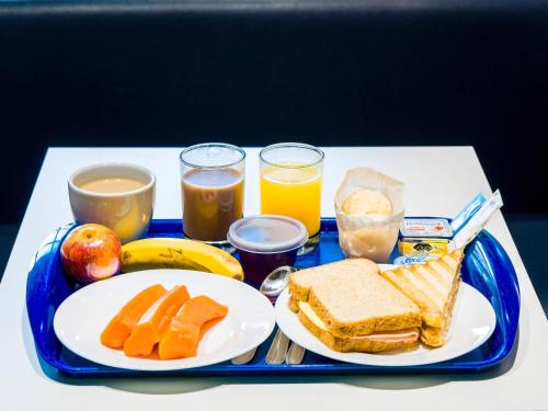 uma bandeja azul com um prato de alimentos e bebidas para o café da manhã em ibis budget Sao Jose do Rio Preto em Sao Jose do Rio Preto