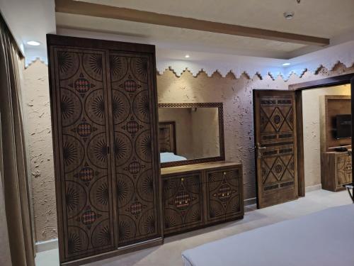 حياة روز للشقق المخدومة في المدينة المنورة: غرفة نوم مع خزانة خشبية كبيرة ومرآة