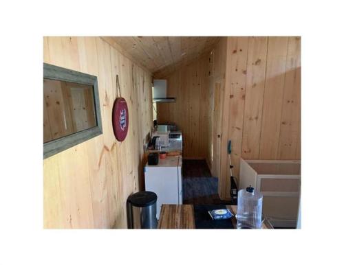 una piccola cucina con pareti in legno e frigorifero di Papa Bear Cabin 