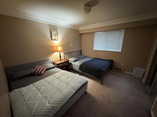 a bedroom with two beds and a window at North Delta Guest House - Scott Rd & Rapid Transit - Airport 20 Min - Free Parking & Fast Wi-Fi in Delta