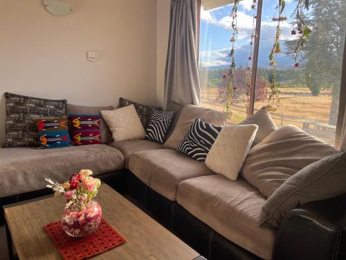 a brown couch in a living room with a window at Central Otago Farmlet in Alexandra