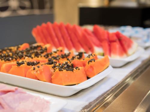 カンピーナスにあるibis budget Campinas Aquidabanのカウンターの食品2皿(フルーツ付)