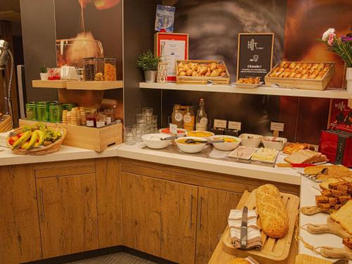 un buffet con pan y otros alimentos a la vista en ibis Clichy Centre Mairie, en Clichy