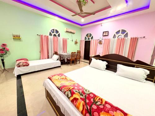 MajuliにあるSugandhalookのベッド2台とリビングルームのある寝室