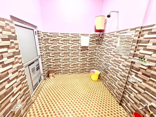 MajuliにあるSugandhalookの黄色いバケツが備わったタイル張りのシャワーを備えたバスルーム